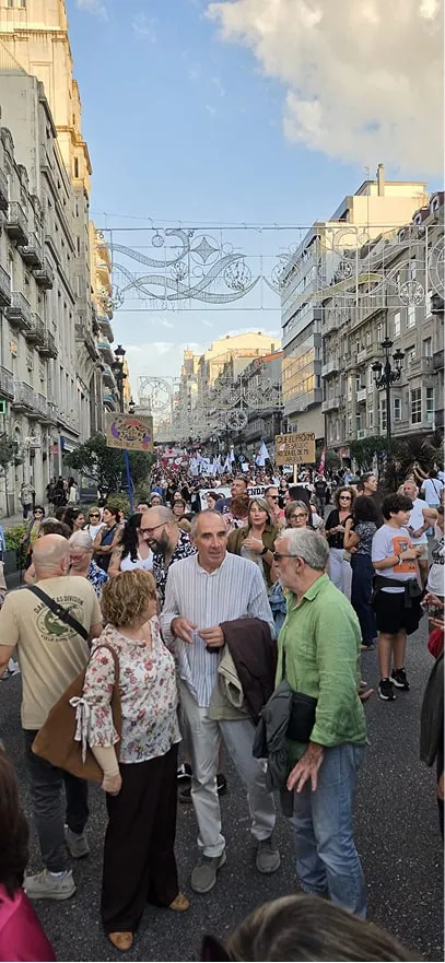 Manifestantes con pancartas y carteles avanzando por una calle del centro de Vigo