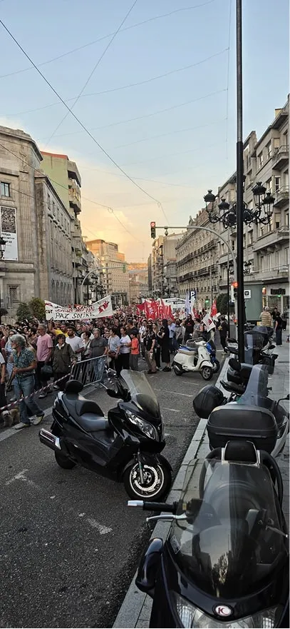Cabecera de la manifestación con banderas y pancartas avanzando por una calle del centro de Vigo