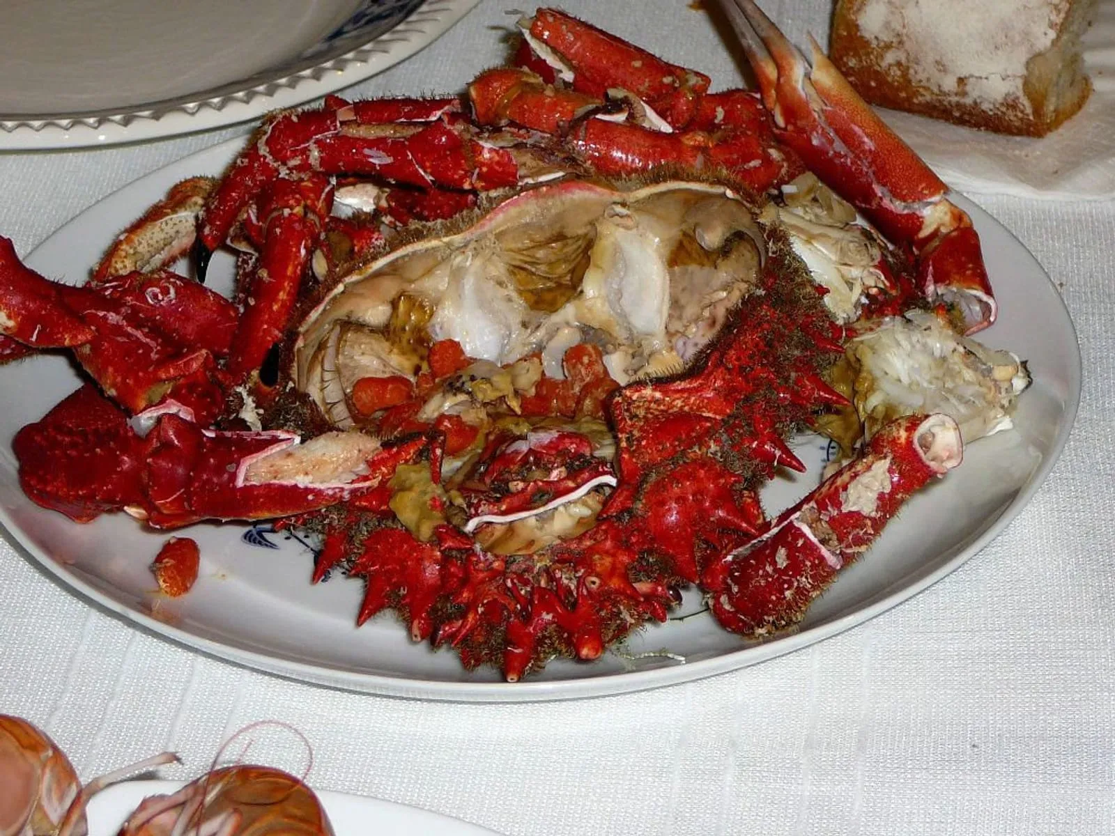 Centolla cocida servida en una fuente, con las patas y el caparazón abiertos