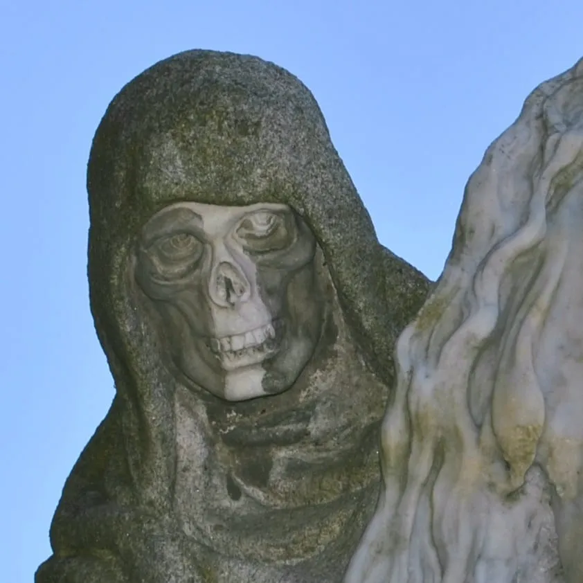 Detalle del rostro de calavera de la Muerte bajo una capucha de granito, en la obra de Asorey