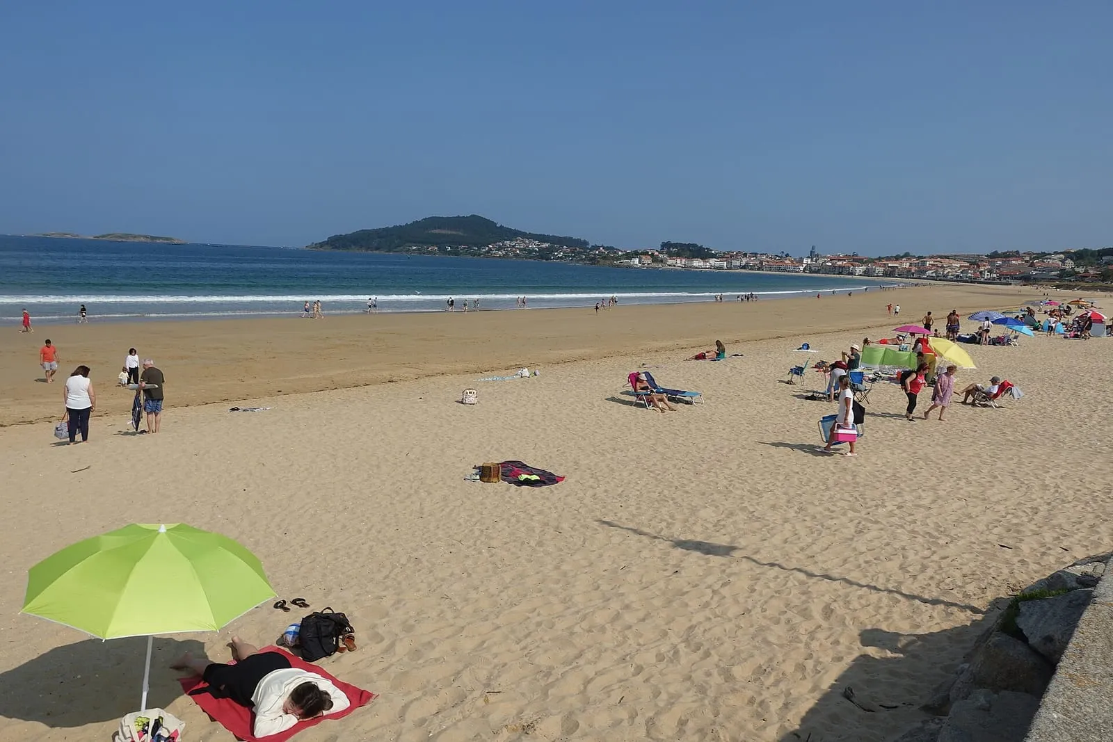 Bañistas y sombrillas en Praia América con Monte Ferro al fondo