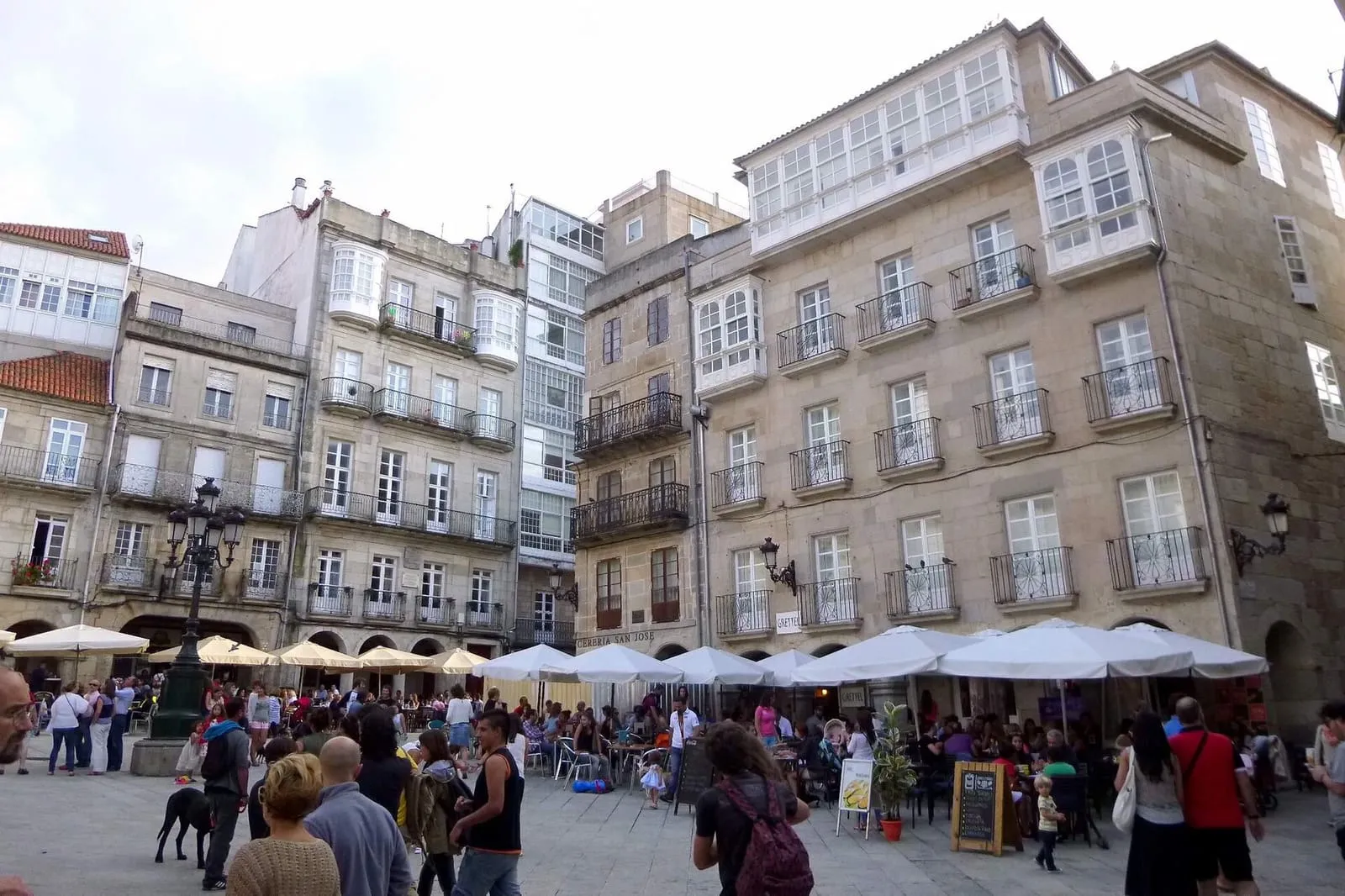 La Praza da Constitución, en el Casco Vello de Vigo, con los soportales, las galerías blancas y las terrazas llenas de gente